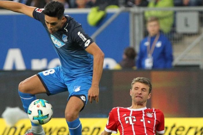 Gelandang Hoffenheim, Nadiem Amiri (kiri), berduel dengan penyerang Bayern Muenchen, Thomas Mueller, dalam partai Liga Jerman di Rhein-Neckar Arena, Sinsheim, 9 September 2017.