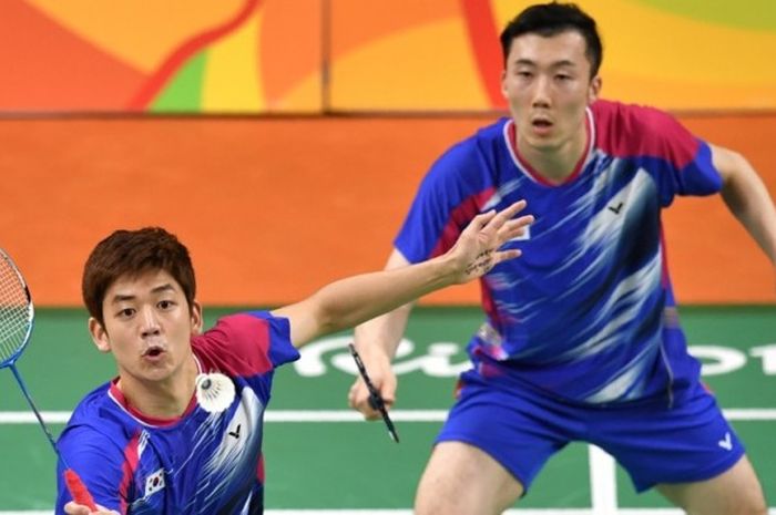 Pasangan ganda putra asal Korea Selatan, Lee Yong-dae (kiri)/Yoo Yeon-seong, mengembalikan kok dari pasangan Taiwan, Lee Sheng Mu Lee/Tsai Chia Hsin, pada babak penyisihan Olimpiade Rio 2016 di Rio de Janeiro, Minggu (12/8/2016).