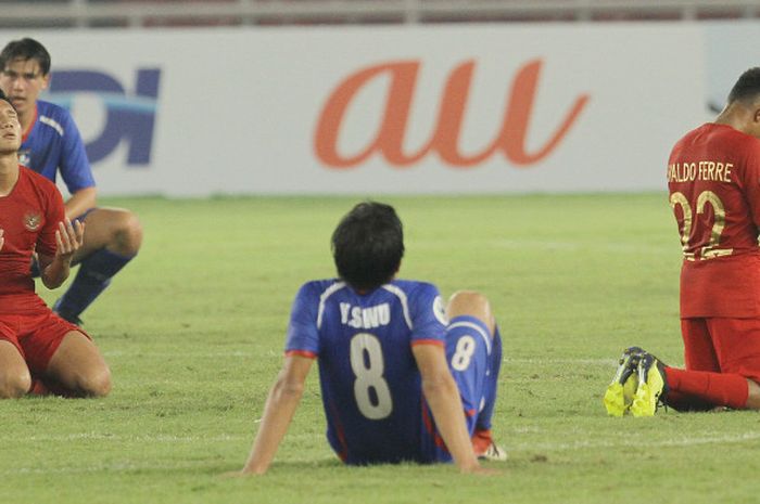 Dua pemain Timnas U-19 Indonesia berdoa penuh sukacita di antara dua pemain Timnas U-19 Taiwan yang berduka usai laga perdana Grup A Piala Asia (Piala AFC) U-19 2018 di Stadion Utama Gelora Bung Karno, Senayan, Jakarta, Kamis (18/10/2018) malam WIB. Timnas U-19 Indonesia menang 3-1.