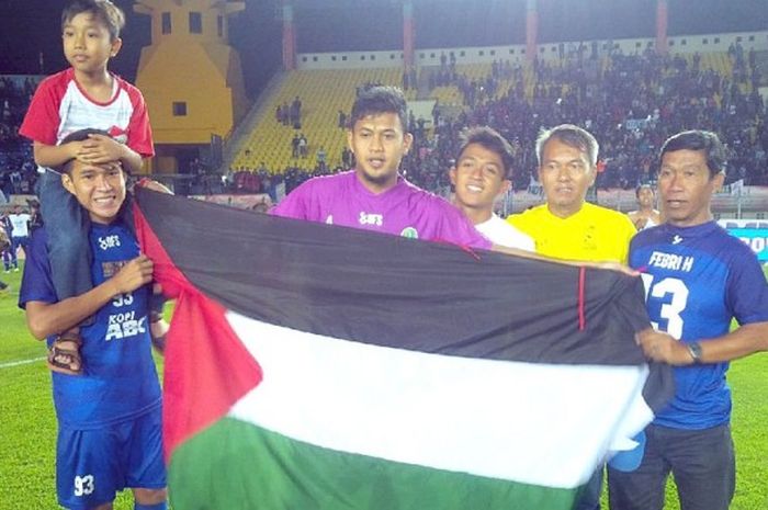 Penjaga gawang tim sepak bola Jawa Barat, Muhammad Natshir, membawa bendera Palestina saat merayakan