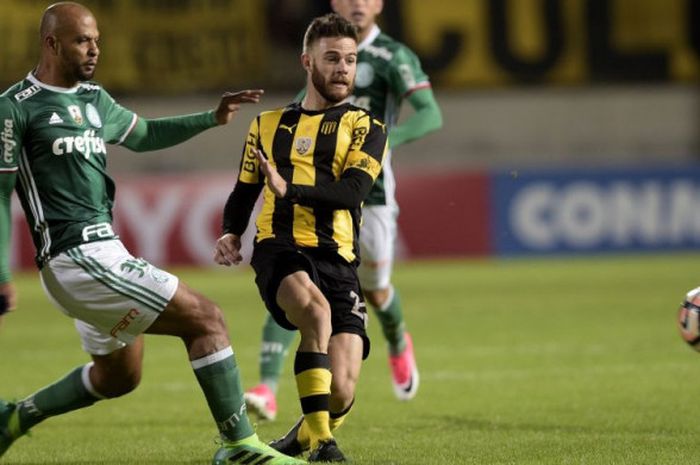 Gelandang Palmeiras, Felipe Melo, berduel dengan pemain Penarol di laga Piala Libertadores di Campeones del Siglo Stadium di Montevideo, 26 April 2017.