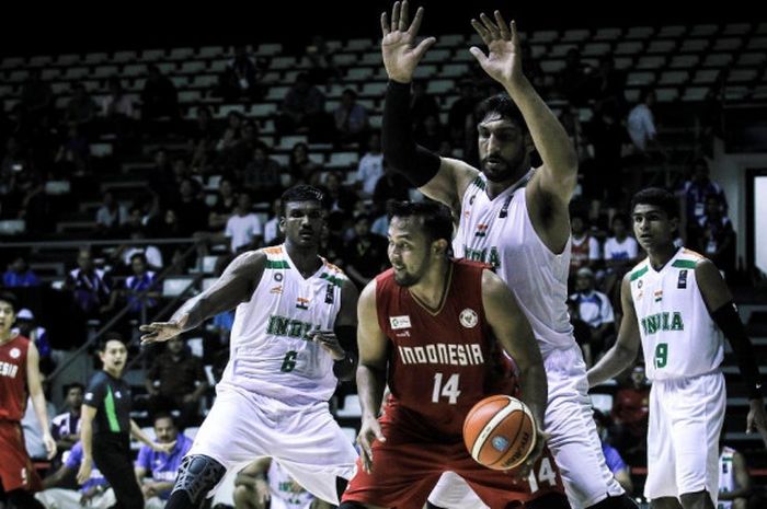 Pebasket nasional Indonesia, Adhi Pratama Putra Prasetyo (jersey merah, #14), berupaya melewati penj