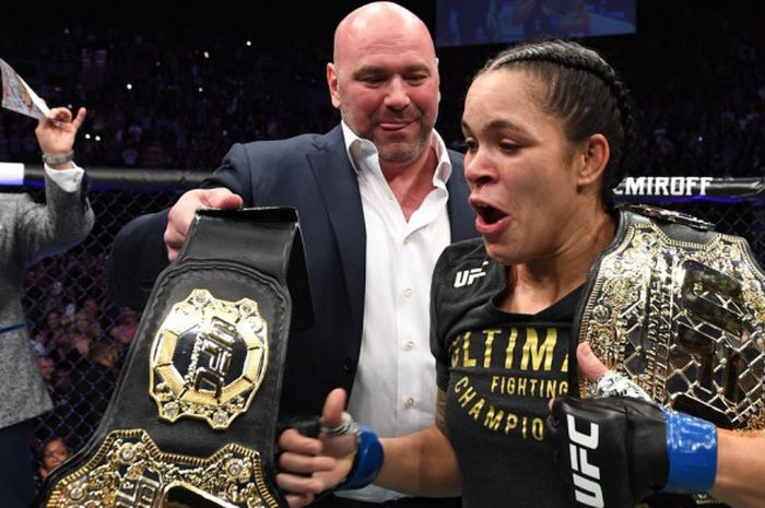 Ekspresi Amanda Nunes (kanan) saat menerima sabuk dari Presiden UFC, Dana White (tengah), dalam laga UFC 232 yang berlangsung Sabtu (29/12/2018) malam waktu Amerika Serikat.