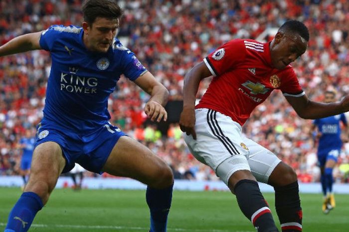 Bek Leicester City, Harry Maguire, mencoba merebut bola dari penyerang Manchester United, Anthony Martial, pada laga Liga Inggris di Stadion Old Trafford, Manchester, pada Sabtu (26/8/2017).