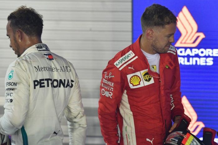  Lewis Hamilton (kiri) dan Sebastian Vettel (kanan) setelah menyelesaikan balapan GP Singapura di Sirkuit Jalan Raya Marina Bay, Minggu (16/9/2018). 