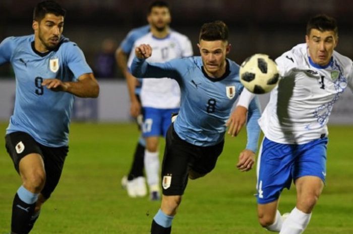 Pemain Uruguay, Luis Suarez dan Nahitan Nandez, dikawal pemain Uzbekistan, Akramjon Komilov, pada laga uji coba di Stadion Centenario, Montevideo, 7 Juni 2018. 