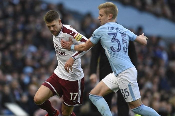 Gelandang Manchester City, Oleksandr Zinchenko,(kanan) berebut bola dengan gelandang Burnley, Johann Ber Gudmondsson (kiri) dalam duel kedua tim dalam ajang Piala FA di Stadion Etihad, Manchester, pada Sabtu (6/1/2017).