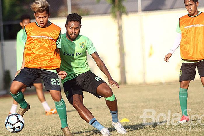 Pemain belakang Persebaya, Fandli Imbiri, berusaha merebut bola dari penguasaan rekan setimnya, Fani Aulia, dalam sesi latihan di lapangan Mapolda Jatim, Jumat (25/8)2017).