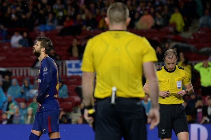 Bek FC Barcelona, Gerard Pique (kiri), meninggalkan lapangan setelah menerima kartu kuning kedua dalam laga Grup D Liga Champions kontra Olympiacos FC di Stadion Camp Nou, Barcelona, Spanyol, pada 18 Oktober 2017.