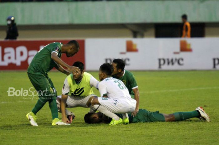 Pemain Persebaya, Osvaldo Haay, mendapat hiburan dari rekan setim dan pemain lawan seusai adu penalti kontra PSMS Medan dalam duel babak delapan besar Piala Presiden 2018 di Stadion Manahan, Solo, Sabtu (3/2/2018) sore WIB.