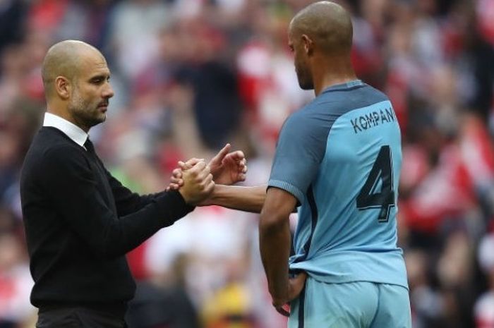 Manajer Manchester City, Josep Guardiola (kiri) berjabat tangan dengan bek Vincent Kompany seusai pertandingan semifinal Piala FA 2016-2017 menghadapi Arsenal di Stadion Wembley, London, Inggris, pada 23 April 2017.