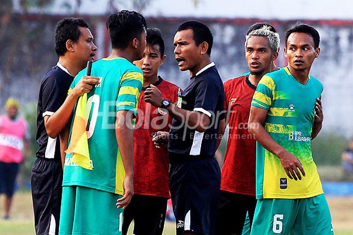 Pemain Madura FC melakukan protes kepada Wasit Rorim Situmerang yang memimpin laga pekan ke-10 Liga 2 2018 antara tuan rumah PS Mojokerto melawan Putra Madura FC di Stadion Gajah Mada Mojosari, Jawa Timur, Rabu (25/07/2018) sore. 