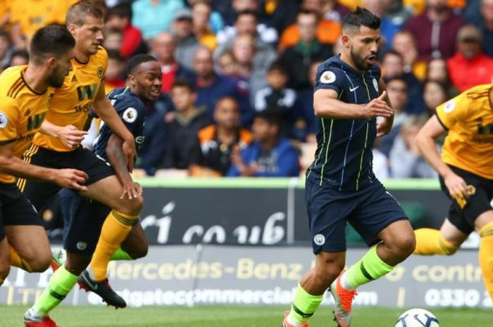 Striker Manchester City, Sergio Aguero, menggiring bola di tengah kawalan ketat pemain Wolverhampton Wanderers dalam partai Liga Inggris di Molineux Stadium, Wolverhampton, 25 Agustus 2018.