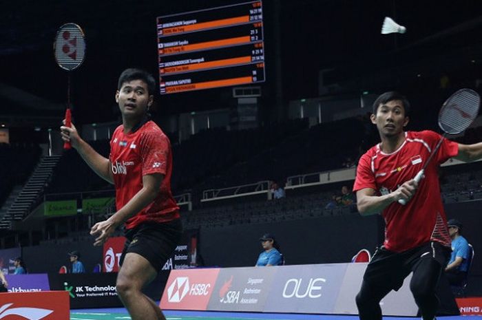 Pasangan ganda putra Indonesia, Angga Pratama/Rian Agung Saputro, mengembalikan kok ke arah Inakarat Apisuk/Tanupat Viriyangkura (Thailand) pada babak pertama Singapura Terbuka yang berlangsung di Singapore Indoor Stadium, Rabu (18/7/2018).