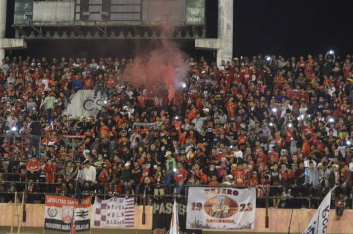 Suporter Persis Solo saat menyalakan smokebomb usai pertandingan melawan Timnas U-19 Indonesia di Stadion Manahan, Solo, Senin (28/5/2018).