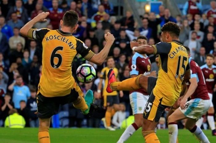  Bek Arsenal, Laurent Koscielny (kiri), meneruskan bola dari tembakan rekannya, Alex Oxlade-Chamberlain, saat melawan Burnley di Turf Moor, Minggu (2/10/2016). 