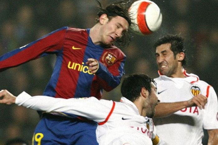 Lionel Messi (atas) menyundul bola di tengah kawalan Raul Albiol dan Marco Caneira dalam partai Copa del Rey antara Barcelona dan Valencia di Camp Nou, 27 Februari 2008.