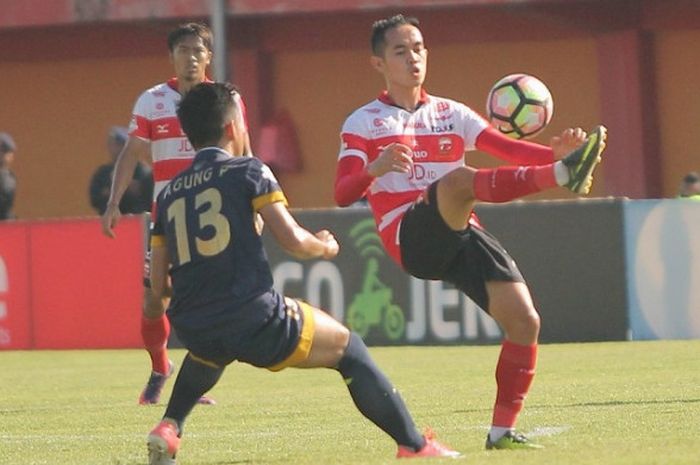 Slamet Nurcahyo dihadang pemain Persela Lamongan, Agung Pribadi.