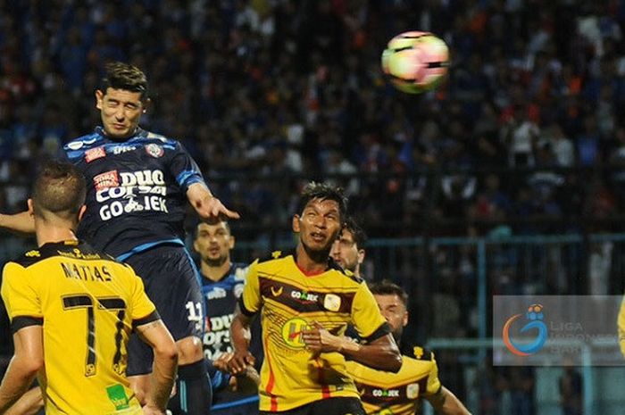 Gelandang Arema FC Esteban Viscarra menyundul bola ke gawang Barito Putera.