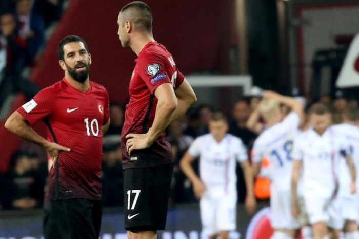 Reaksi pemain timnas Turki, Arda Turan (kiri) dan Burak Yilmaz, di tengah selebrasi gol pemain Islandia di belakang mereka dalam partai Kualifikasi Piala Dunia 2018 di Eskisehir Stadium, 6 Oktober 2018.