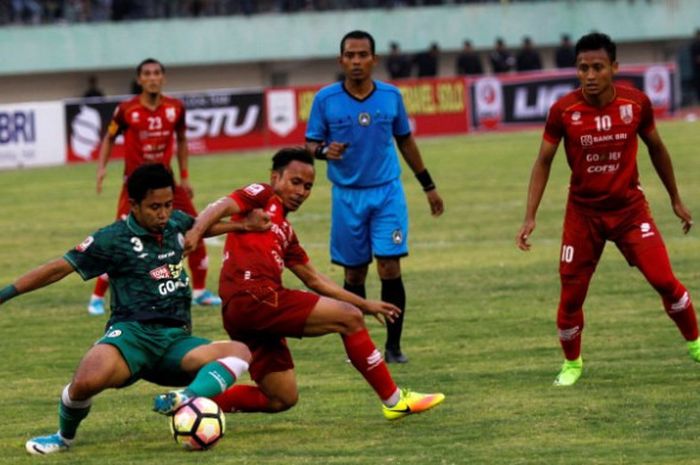 Bek PSS Sleman, Bagus Nirwanto (kiri) berebut bola dengan pemain Persis Solo, Eli Nasoka pada laga kedua Grup A 16 Besar Liga 2 musim 2017 di Stadion Manahan, Solo, Minggu (24/9/2017) sore. 