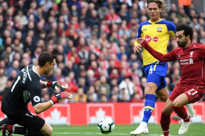 Mohamed Salah (kanan) menembak ke gawang kawalan Alex McCarthy dalam partai Liga Inggris antara Liverpool FC lawan Southampton di Stadion Anfield, Liverpool, 22 September 2018.