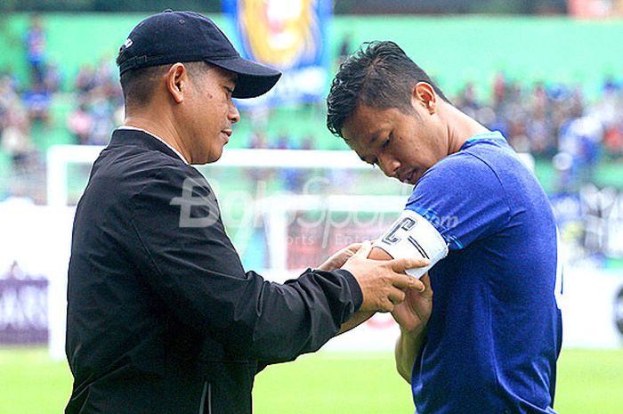 Pelatih Arema FC, Joko Susilo (kiri), membantu memasang ban kapten ke lengan Dendi Santoso dalam laga ujicoba melawan PSIS Semarang di Stadion Gajayana Malang, Jawa Timur, Kamis (04/01/2017) sore.