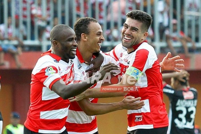 Striker Madura United, Peter Odemwingie (tengah), merayakan gol bersama rekan setimnya, Greg Nwokolo (kiri) dan Fabiano Beltrame, seusai membobol gawang Bali United dalam laga Liga 1 di Stadion Gelora Pamelingan Pamekasan, Jawa Timur, Minggu (16/04/2017).