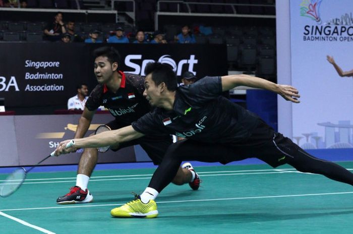 Pasangan ganda putra nasional Indonesia, Angga Pratama/Rian Agung Saputro, berupaya mengembalikan kok dari lawan mereka, Aaron Chia/Woii Yik Soh (Malaysia), pada babak kedua turnamen Singapore Open 2018 yang berlangsung Singapore Indoor Stadium, Singapura, Kamis (19/7/2018).