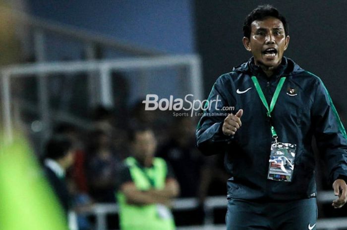 Pelatih timnas u-19 Indonesia, Bima Sakti, memberikan instruksi pada laga melawan timnas u-19 Jepang di Stadion Utama GBK, Minggu (25/3/2018). 