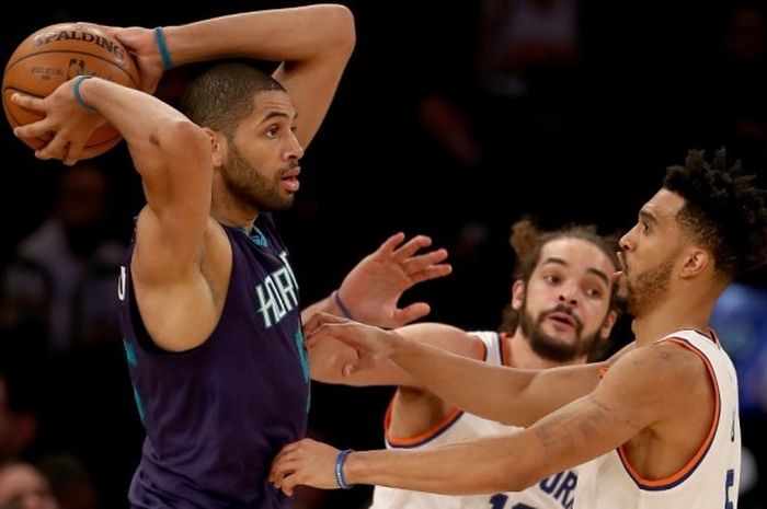 Small forward Charlotte Hornets, Nicolas Batum (jersey ungu, #5), bersiap melepas operan seraya dijaga pemain New York Knicks, Joakim Noah (belakang) dan Courtney Lee, pada laga musim reguler NBA di Madison Square Garden, New York City, Amerika Serikat, Jumat (27/1/2017).