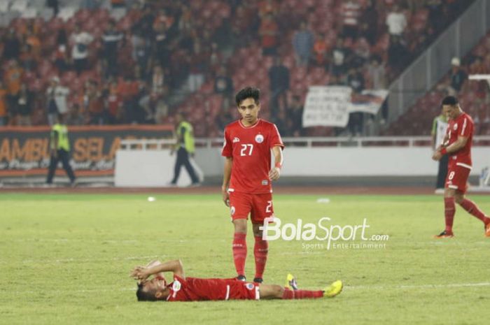    Pemain Persija Jakarta, Fitra Ridwan, mendekati Riko Simanjuntak yang terlentang di lapangan seus