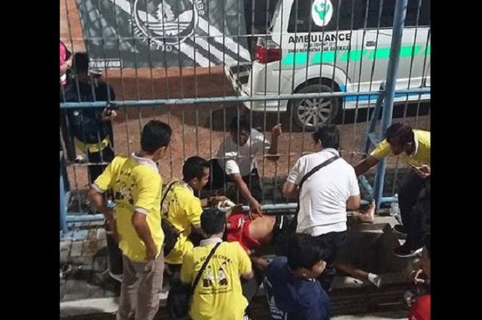 Seorang suporter Bali United, Nengah Murjana, terjatuh saat pasang spanduk di Stadion Gelora Bangkalan, Minggu (3/6). Murjana langsung dibawa ke rumah sakit terdekat. 