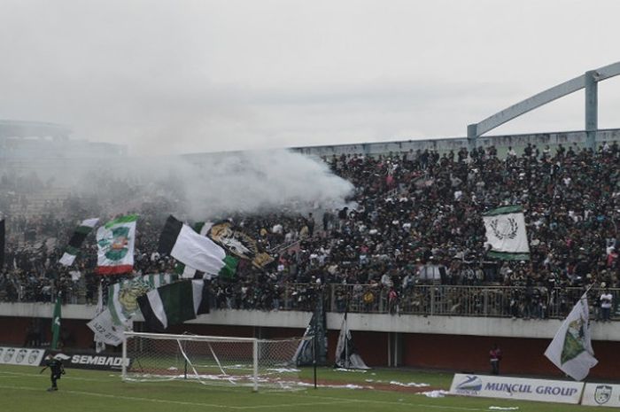 Suporter PSS Sleman menyalakan smokebomb saat laga uji coba PSS Sleman Vs PSMS Medan, di Stadion Internasional Maguwoharjo, Minggu (4/3/2018).