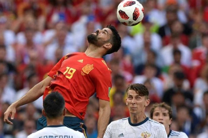 Striker Spanyol, Diego Costa (atas) mencoba menanduk bola di tengah kawalan pemain Rusia dalam partai babak 16 besar Piala Dunia 2018 di Stadion Luzhniki, Moskow, 1 Juli 2018.