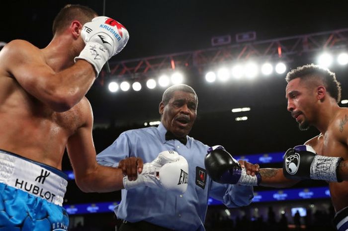 Wasit Robert Byrd mempersiapkan pertarungan ronde ketiga yang memperebutkan gelar kelas berat ringan antara petinju Rusia, Sergey Kovalev (kiri), dan Andre Ward (Amerika Serikat/AS) di T-Mobile Arena, Las Vegas, Nevada, AS,  19 November 2016.