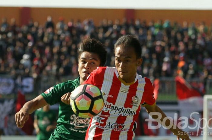 Dimas Galih (Persebaya Surabaya) sedang berusaha menghentikan pemain Persepam.