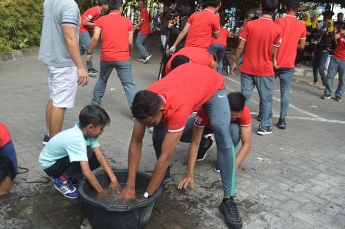 Pemain timnas U-19 Indonesia saat lomba tangkap belut di lapangan parkir UNY, Jumat (17/8/2018).