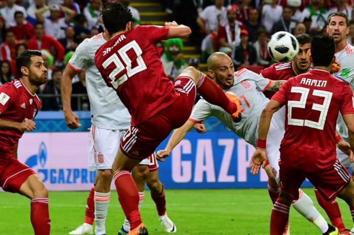 Aksi gelandang tim nasional Spanyol, David Silva (tengah), saat mencoba melepaskan tembakan akrobatik di antara kawalan para pemain Iran dalam laga Grup B Piala Dunia 2018 di Stadion Kazan' Arena, Kazan, Rusia, pada Rabu (20/6/2018).