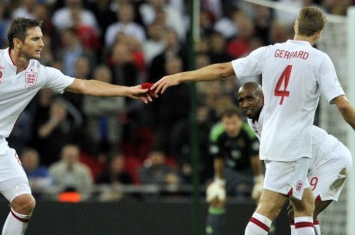  Mantan kapten timnas Inggris, Steven Gerrard (kanan), memberikan ban kapten kepada Frank Lampard (kiri) pada laga kualifikasi Piala Dunia 2014 melawan Swedia di stadion Wembley, 11 September 2012. 