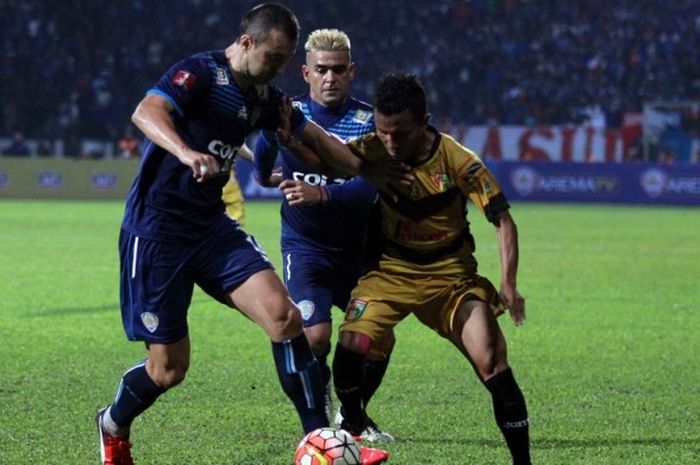 Pemain Mitra Kukar, Hendra Adi Bayaw (kanan), berusaha mempertahankan bola dari hadangan dua pemain Arema Cronus, Goran Ganchev (kiri) dan Cristian Gonzales, dalam lanjutan Kejuaraan Sepak Bola Torabika (TSC) 2016 di Stadion Gajayana, Kab Malang, Jumat (29/9/2016).