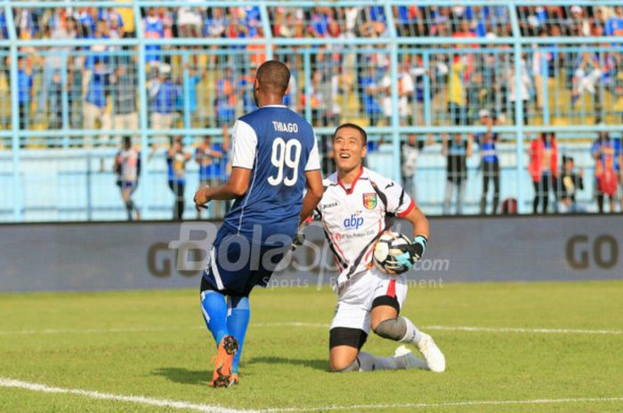 Kiper Mitra Kukar, Yoo Jae-hoon, mengamankan bola dari striker Arema FC, Thiago Furtuoso, dalam duel pekan pertama Liga 1 2018 di Stadion Kanjuruhan, Malang, Sabtu (24/3/2018)