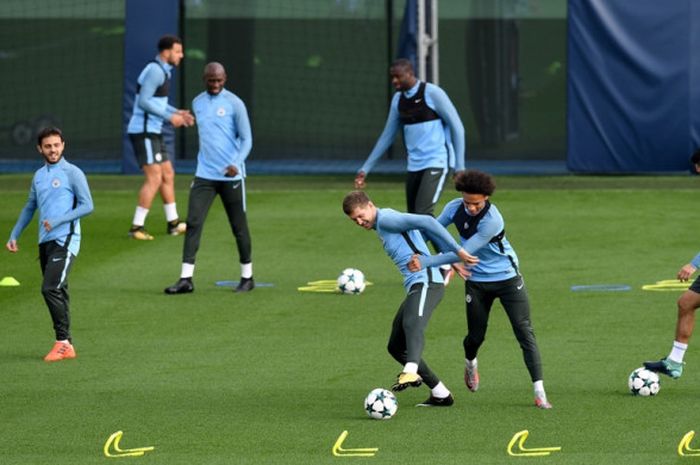 Bek Manchester City, John Stones (tengah), berduel dengan Leroy Sane dalam sesi latihan di City Football Academy, Manchester, Inggris, pada 25 September 2017.