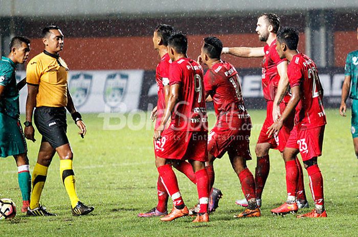 Pemain PDRM FA (merah) memprotes keputusan wasit Wendi Umar yang dianggap merugikan mereka saat melawan PSS Sleman dalam laga Coppa Sleman di Stadion Maguwoharjo, Sleman, Selasa (17/1/2018) malam.