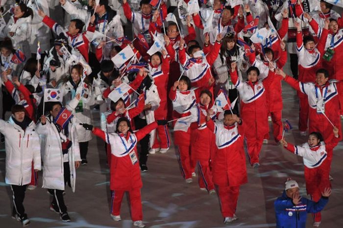 Delegasi Korea Utara dan Korea Selatan melambaikan bendera negara mereka bersama bendera unifikasi Korea pada upacara penutupan Olimpiade Musim Dingin Pyeongchang 2018 di Stadion Pyeongchang, Minggu (25/2/2018).   