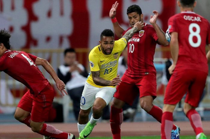 Gelandang Jiangsu Suning, Alex Teixeira (kuning), berusaha melewati sergapan para pemain Shanghai SIPG dalam pertandingan babak 16 besar Liga Champions Asia di Shanghai, CHina, pada 24 Maret 2017.