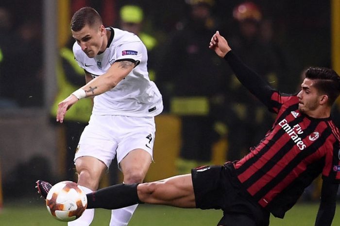 Striker AC Milan, Andre Silva (kanan), berduel dengan bek AEK Athens, Ognjen Vranjes, dalam laga Grup D Liga Europa di Stadion San Siro, Milan, Italia, pada 19 Oktober 2017.