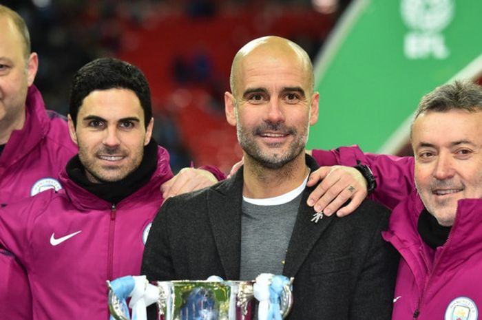 Manajer Manchester City, Josep Guardiola, berpose memegang trofi Piala Liga Inggris bersama asistennya, Rodolpho Borrell, Mikel Arteta, dan Domenec Torrent, seusai mengalahkan Arsenal dalam laga final di Stadion Wembley, London, pada 25 Februari 2018.