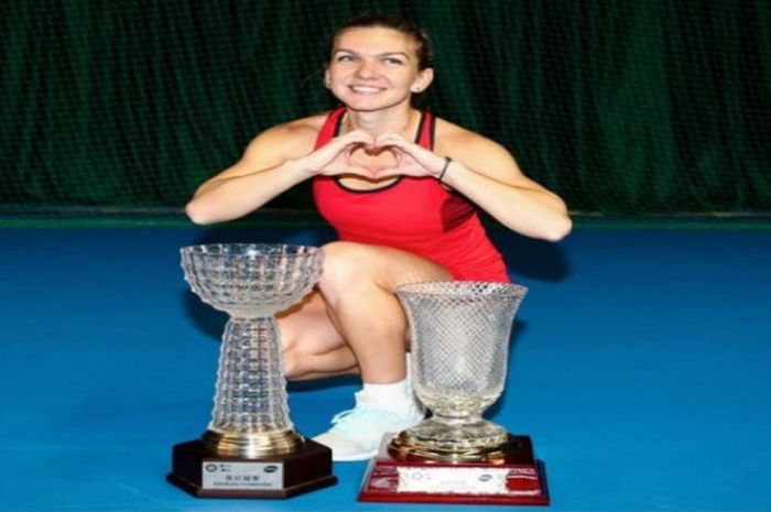 Simona Halep berpose dengan dua piala yang diraihnya secara sekaligus usai memenangi dua laga fina Shenzhen Open 2018, Sabtu (6/1/2018).