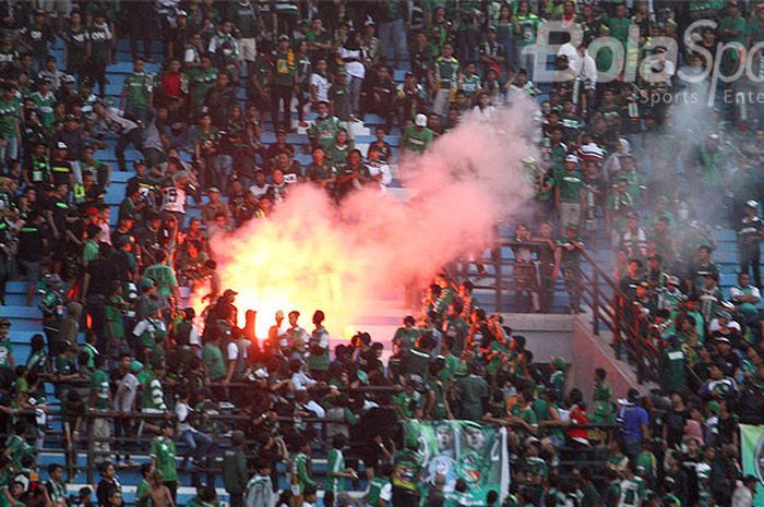 Bonek tribun sisi utara menyalakan flare usai laga Persebaya Surabaya kontra Barito Putera, Minggu (8/4/2018).